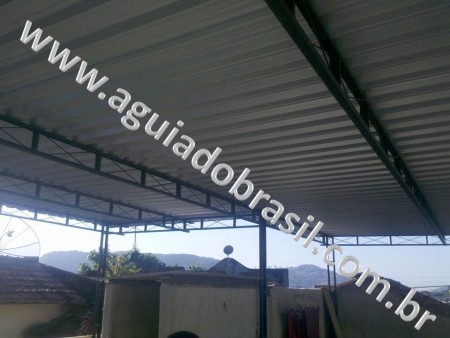 ESTRUTURA METÁLICA EM FERRO U2 COM TELHAS GALVALUME, PINTURA EM PRIMMER ZARCÃO CINZA, E CALHA ARTESANAL DE ALUMÍNIO.